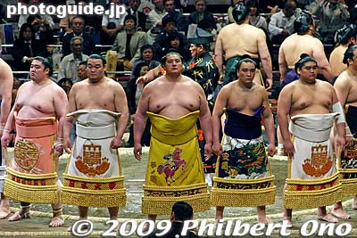 Wrestlers wait until everyone is on the ring. Notice that Takamisakari (second from the left) and the rikishi on the far right have almost the same aprons. They will serve as the sword bearer and dew sweeper for the yokozuna ring-entering ceremony.
Keywords: tokyo sumida-ku ward ryogoku kokugikan sumo tournament ozumo rikishi wrestlers japankokugikan japansumo